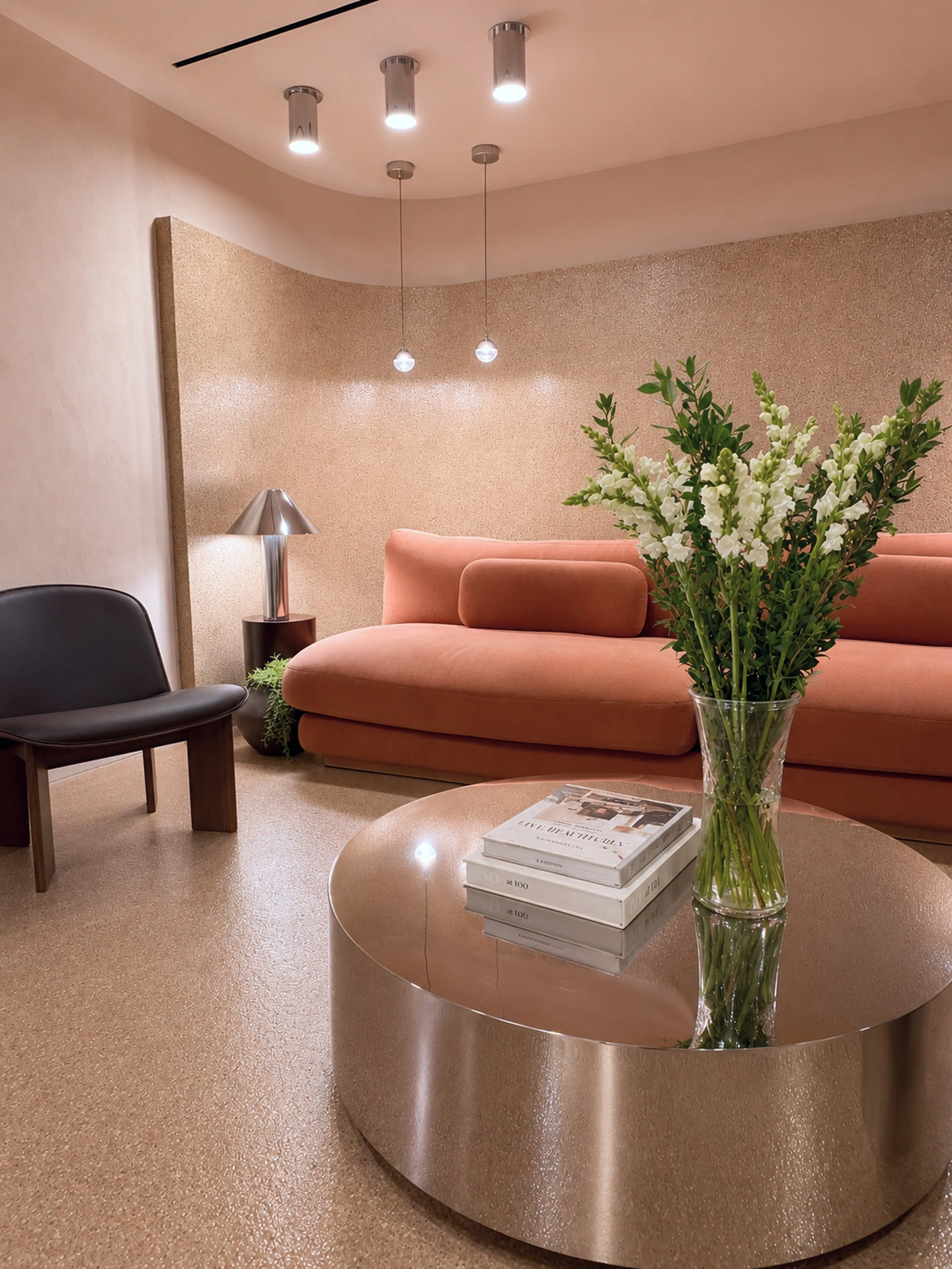 Intimate seating nook with coral sofa and floral arrangement