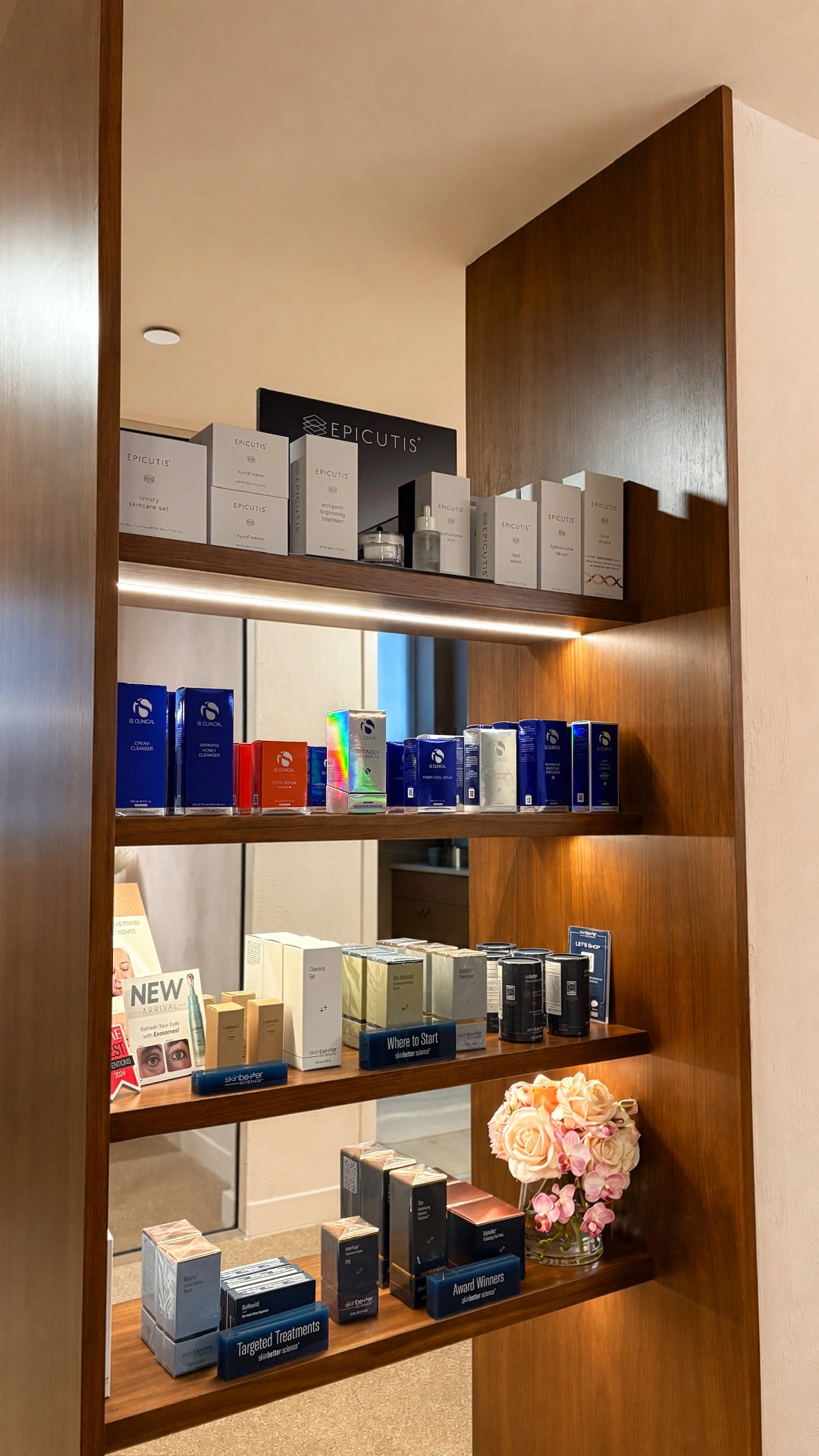 Backlit walnut shelving with Epicutis, iS Clinical and skinbetter products