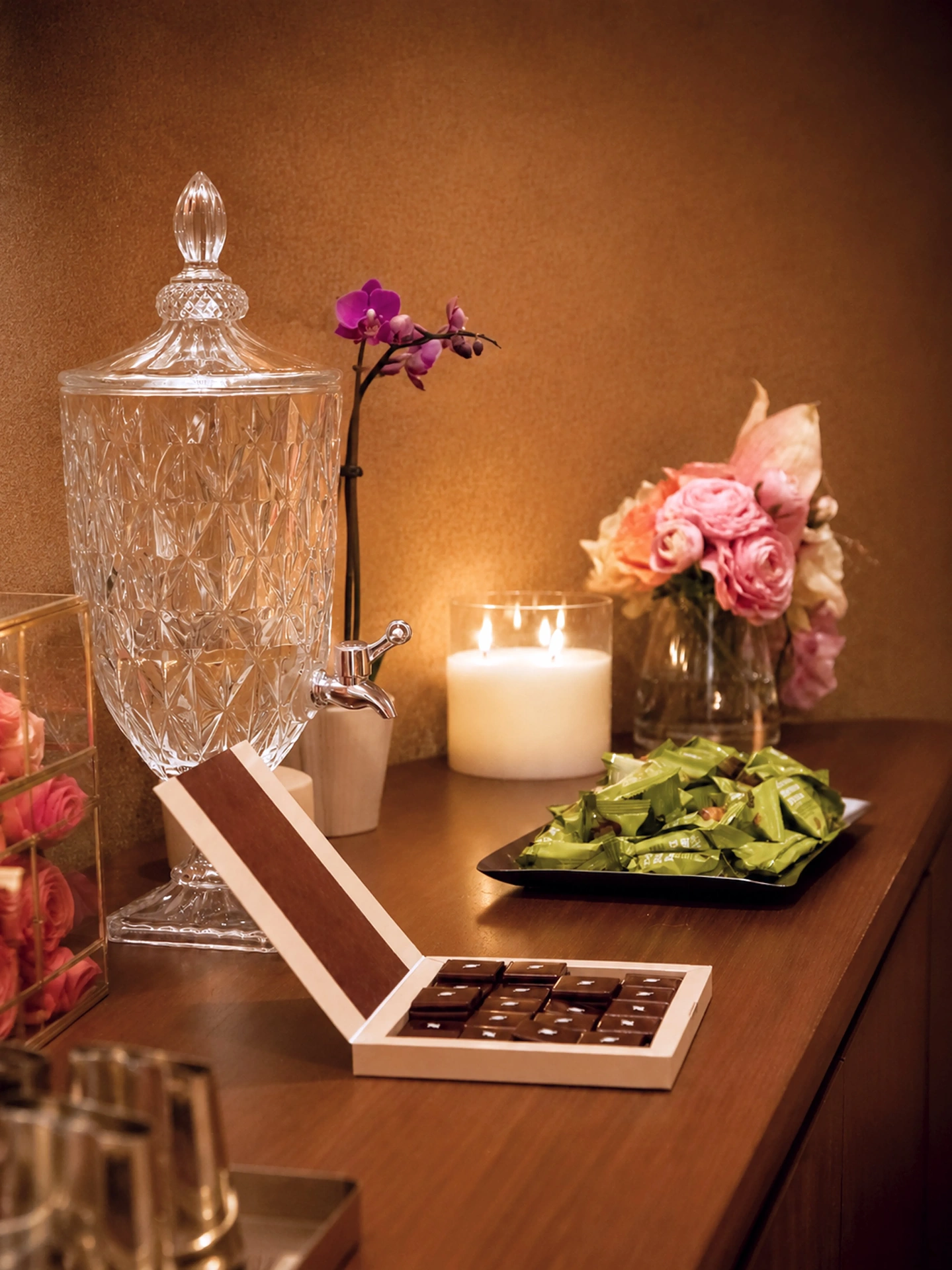 Refreshment station with crystal dispenser, orchids and chocolates