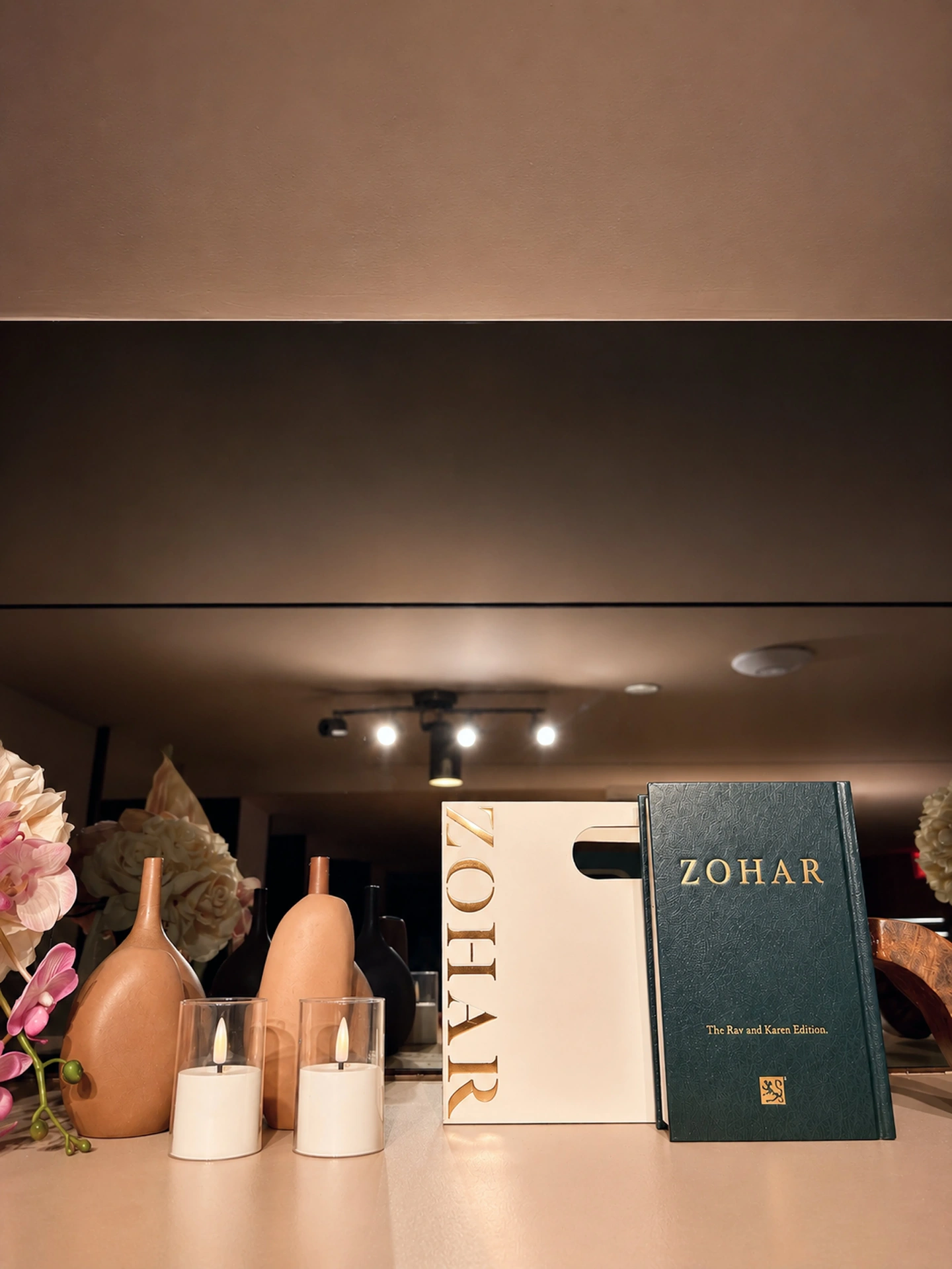 Gold-embossed ZOHAR book and candles styled on a lounge shelf